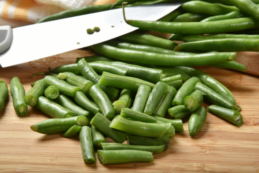 Fresh cut green beans on a cutting board.